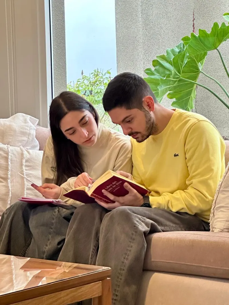 Pareja leyendo la Biblia juntos en un sillón